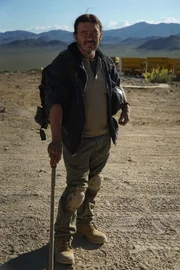 Participant William Sherman holds his helmet with a walking stick outside of the Darwin Mine.