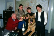 Kommissar Moser (Tobias Moretti, r.), Peter Höllerer (Wolf Bachofner, 2.v.l.), Rex und Max Koch (Fritz Muliar, l.) heißen ihren neuen Kollegen Christian Böck (Heinz Weixelbraun, 2.v.r.) willkommen.