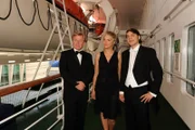Zusammen mit seinem Vater (Jörg Schüttauf, l.) tritt der begabte Jungpianist Alexander (Marco Bretsch-Coschignano, r.) die gewonnene Konzertreise auf dem Traumschiff an. Auch Inka (Inka Bause, M.) ist von seinem Talent begeistert.