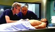 Dr. Sid Hammerback (Robert Joy, li.) und Dr. Sheldon Hawkes (Hill Harper) untersuchen die Leiche von Mitch Henson (Joshua Snyder). Was war die Todesursache?