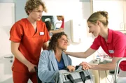 Fiete (Adrian Gössel, l.) darf sich unter Alexandra Lundqvists (Friederike Linke, r.) Aufsicht um die schwangere Patientin Nicole Fritsch (Katharina Spiering, M.) kümmern.