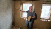 Katrins Vater Manfred kümmert sich um das Verputzen der Wände
