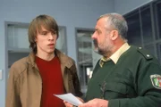 Jochen (Jona Mues, li.) taucht bei der Autobahnpolizei auf, um Herzberger (Dietmar Huhn) auszuhorchen. Dabei erfährt er, dass Weber an der Partydroge starb.