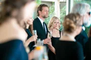 Max (Julian Looman) und Miranda (Elen Rhys) hören gespannt der Rede des Gastgebers zu.