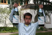 Ganz schön schwer: Willi mit zwei Doppelmagnumflaschen vor der Sektkellerei Schloss Wachenheim.