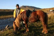 Willi mit einem Islandpferd am Fluss.