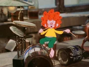 Der Pumuckl baut sich ein Schlagzeug aus Blechbüchsen und veranstaltet mit seinem Trommeln einen Höllenlärm.