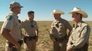 Wardens Sims, Stewart, Spencer, and Collins talk in a field