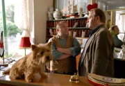 Hotel Flamingo Behringer (Jan-Gregor Kremp, r.) holt sich bei Herrn Hübner (Gustav Peter Wöhler, r.) den Schlüssel von Zimmer 14. Schoßhund Elvis wartet neben der Portiersglocke.