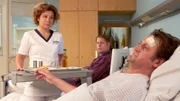 Mit Jakob Heilmanns Hilfe, ist nun klar, wer der unbekannte Patient ist: Anno Pesch (Ingo Naujoks, re.), ein sehr bekannter Koch, der sogar eine eigene Koch-Show hat. Jakob hatte die Idee, etwas Besonderes für ihn zu kochen, vielleicht macht das Anno etwas zugänglicher. Doch als Schwester Ulrike (Anita Vulesica, li.) ihm das Extra-Menü bringt, will er davon nichts wissen und schickt sie wieder weg. Annos Zimmernachbar Dieter Müller (Johannes R. Voelkel, hi.mi.) hingegen, freut sich über das besondere Mal.