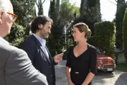 Alessandro (Kerem Can, M.) begrüßt Laura (Wolke Hegenbarth, rechts) herzlich, entfernt noch schnell das Preisschild von ihrem Kleid und stellt ihr seinen Vater Emanuele (Rolf Sarkis, l.) vor.
