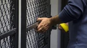 HSI Special Agent Marino locks the door to a temporary cell holding a traveler whose bag contained nearly four kilograms of cocaine.