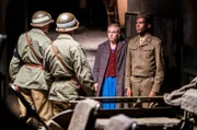 George (Reomy D. Mpeho) wird im Beisein von Marie (Elisa Schlott) von den Wachen schlecht behandelt.
