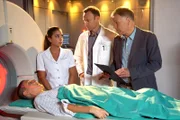 Pia Heilmanns (Hendrikje Fitz, liegend) Krebstherapie ist beendet. Nun führen ihr Mann Roland (Thomas Rühmann, re.) und Dr. Martin Stein (Bernhard Bettermann, mi.) die Abschlussuntersuchung durch. Schwester Arzu (Arzu Bazman, li.) steht Pia bei. Obwohl Roland und Martin guter Dinge sind, ist Pia eher verhalten. Sie hat einen geschwollenen Lymphknoten ertastet.