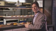 Biochemist, Lee Cronin, Ph.D, University of Glasgow, with a plate of the traditional Scottish dish haggis. Cronin discusses the creation of the recipe for haggis as a metaphor for the natural law of evolution that refines chemicals, in steps, over time, to create living things.