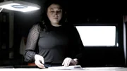 Eine Frau steht und schaut auf ein Dokument