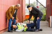 Herr Naumann (Guido Broscheit, M.) wurde angegriffen - Klaus Schmitz (Hartmut Volle, l.) und Reinhard Bielefelder (Bill Mockridge, r.) kommen ihm zu Hilfe.