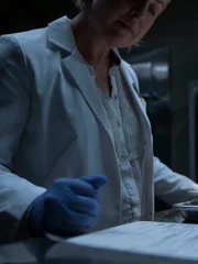 Forensic document examiner looking at signature in lab.