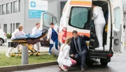 Ein Rettungswagen verunfallt ausgerechnet vor der Notaufnahme! Ben Ahlbeck (Philipp Danne, 3.v.l. mit Komparsen, l.) kümmert sich um den Fahrer, während Julia Berger (Mirka Pigulla, 3.v.r.) den Zustand von Dr. Niklas Ahrend (Roy Peter Link) checkt. Der beliebte Oberarzt war im Fahrzeug, als der Unfall passierte.