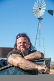 Danny Thompson standing behind a car door.
