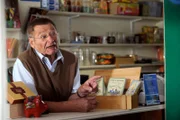 Alois (Erich Hallhuber sen.) wartet in seinem Kiosk auf die nächsten Kunden.