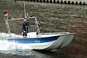 Frank van Dijk (Niklas Osterloh) inspiziert vom Boot aus das Ufer.