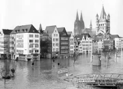 Das Rheinhochwasser hat im Februar 1970 die Rheinuferstraße, die Schiffsanleger der Köln-Düsseldorfer und die tiefergelegenen Straßen der Kölner Altstadt überflutet. Im Hintergrund der Dom und die Kirche Groß St. Martin (r).