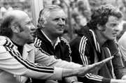 Die Fußball-Weltmeisterschaft in Deutschland: Bundestrainer Helmut Schön (l) versucht an der Seite seines Co-Trainers Jupp Derwall (M) beruhigend auf die Aktionen seiner Mannschaft einzuwirken. Neben ihnen sitzt der ausgewechselte Mittelfeldspieler Herbert Wimmer (r). Die deutsche Fußballnationalmannschaft gewinnt im ausverkauften Düsseldorfer Rheinstadion das Weltmeisterschaftsspiel der 2. Finalrunde gegen Jugoslawien mit 2:0.
