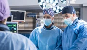 Gretas Bandscheibe muss operiert werden, doch als Dr. Matteo Moreau (Mike Adler, rechts) und Dr. Theresa Koshka (Katharina Nesytowa, links) gerade loslegen wollen, kommt es zu Komplikationen und die OP muss abgebrochen werden (mit Jane Chirwa, 2. von rechts).
