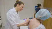 Shot of Dr Emma marking up Josée for her surgery.
