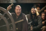 Flint (Toby Stephens, l.) und Silver (Luke Arnold, r.) streiten über den Schatz, während die Piraterie offiziell verboten wird.