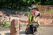 Alice Roberts mit den riesigen römischen Köpfen, die in den römischen Bädern in Carlisle entdeckt wurden