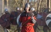 König Cnut steht mit seinen Soldaten im Rücken auf dem Schlachtfeld.