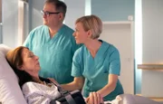 Erika Wildenhorst (Daniela Ziegler, li.) wird nach ihrer OP wach und Dr. Kathrin Globisch (Andrea Kathrin Loewig, re.) und Hans-Peter Brenner (Michael Trischan, mi.) müssen ihr sagen, dass sie den Eingriff unvollendet abbrechen mussten. Da eine weitere OP aufgrund ihrer Herzerkrankung nicht infrage kommt, wird Erika Einschränkungen in der Beweglichkeit ihres Armes zurückbehalten.