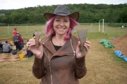 Alice Roberts mit Metallbeilköpfen, die im Trelai Park entdeckt wurden