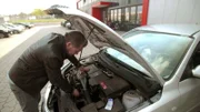 Det Müller schaut in den Motorraum des alten Mazda