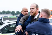 Tobias (Patrick Müller, M.) muss von zwei Beamten (Komparsen) festgehalten werden, als David ihm die Hiobsbotschaft überbringt.
