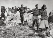 Eine Reihe griechischer Partisanen, Männer und Frauen, marschieren auf einem Pfad auf einem Hügel in der Nähe von Athen, um sich den alliierten Truppen anzuschließen, die gerade gelandet sind. In der Nähe von Athen (Griechenland), Oktober 1944.