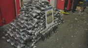 Packages of suspected narcotics found within boxes of garlic stacked behind an HSI Los Angeles sign.