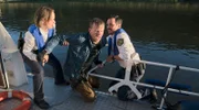 Kommissarin Jana Macourek (Barbara Prakopenka, l.) und Kommissar Moritz Krätschmer (Ferdi Özten, r.) retten Kevin Holzer (Tillmann Eckard, M.) aus dem Wasser und holen ihm auf die "Elbaue".