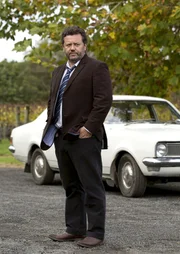 Der unkonventionelle Detective Mike Shepherd (Neill Rea) fährt ein Museumsstück als Dienstwagen. In "Brokenwood" nimmt er seine Arbeit auf, um den Tod eines Farmers aufzuklären.