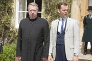 Father Brown (Mark Williams, l.) und Sid Carter (Alex Price, r.) stehen vor einem Rätsel. Sie können sich die schrecklichen Ereignisse der vergangenen Tage nicht erklären.
