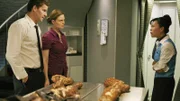 Auf einem Flug nach Shanghai wurde in der Großküchenmikrowelle eine Leiche gefunden. Eine Flugbegleiterin (Lydia Look, r.) unterrichtet Booth (David Boreanaz) und Brennan (Emily Deschanel), die zufällig an Bord sind und sich zwangsläufig des Falles annehmen.