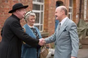 Sir Mortimer (Laurence Kennedy, l.), der Bruder von "Onkel Mirth", begrüßt Father Brown (Mark Williams, r.) und Mrs. McCarthy (Sorcha Cusack, M.). Noch ahnen sie nicht, dass der Abend sie in Angst und Schrecken versetzen wird.