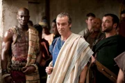 Während Spartacus einen Kampf nach dem anderen gewinnt, machen sich Batiatus (John Hannah, M.), Drago (Peter Mensah, l.) und Ashur (Nick Tarabay, r.) auf, um am Sklavenmarkt neue Sklaven zu ergattern ...