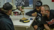 Rick Ness (l.) gießt Gold auf der Goldwaage, während Buzz Legault (r.) und Trey Charlie (2.v.r.) zusehen