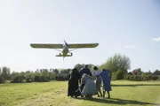Father Brown (Mark Williams, l.), Arthur Le Broc (Rupert Vansittart, 2.v.l.), Lady Felicia (Nancy Carroll, M.), Meg Le Broc (Leah Whitaker, 2.v.r.) und Mrs McCarthy (Sorcha Cusack, r.) gehen in Deckung, als der Flieger direkt auf sie zusteuert.