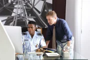 JP Hooper (Tobi Bakare) zeigt seinem Chef DI Jack Mooney (Ardal O'Hanlon) neuste Ergebnisse der Ermittlungen.