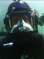 Kris Kelly looks at the camera underwater as he goes down for a dive.
