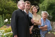 Father Brown (Mark Williams l.), Sid Carter (Alex Price, 2.v.l.), Lady Felicia (Nancy Carroll, 2.v.r.) und Mrs. McCarthy (Sorcha Cusack, r.) halten stets zusammen.